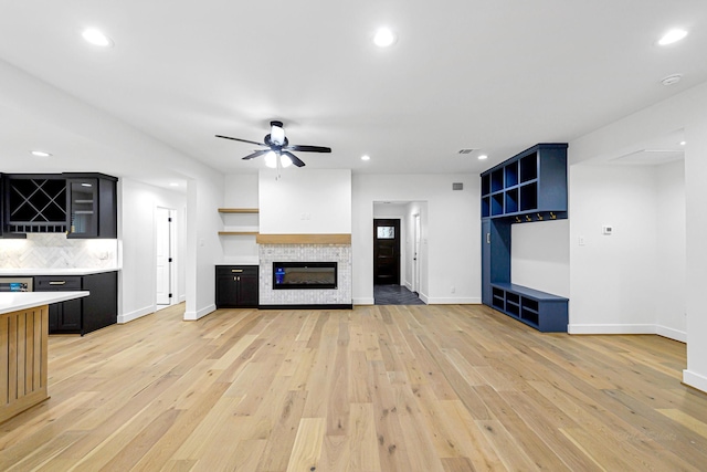 unfurnished living room with ceiling fan and light wood-type flooring