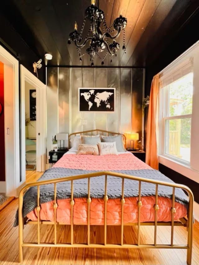 bedroom featuring wood-type flooring, a notable chandelier, and wood ceiling