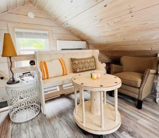 sitting room featuring lofted ceiling, a wall mounted AC, wood walls, hardwood / wood-style flooring, and wood ceiling