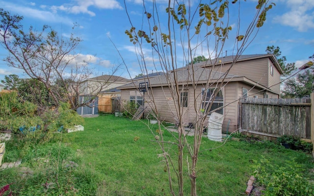 back of house featuring a yard and a storage unit