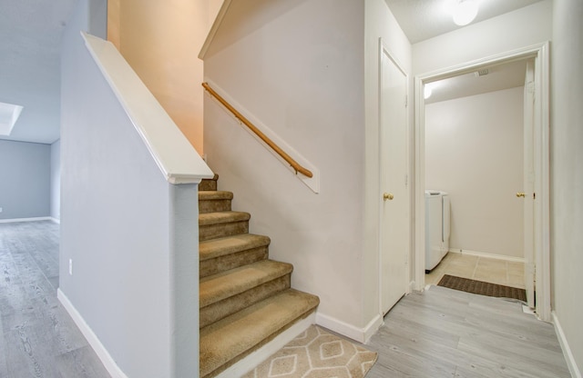 stairway featuring hardwood / wood-style floors and independent washer and dryer