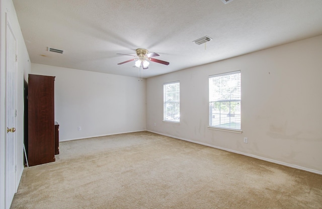 spare room featuring ceiling fan and light carpet