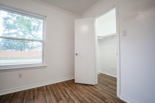 unfurnished bedroom with dark wood-type flooring, a closet, and crown molding