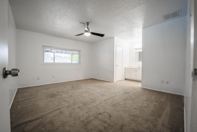 spare room with a textured ceiling, ceiling fan, and carpet floors