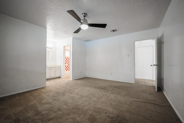 unfurnished room with a textured ceiling, ceiling fan, and carpet flooring