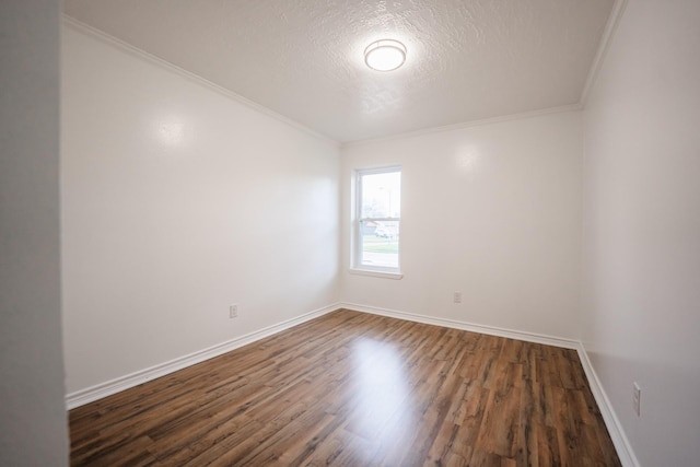 empty room featuring ornamental molding, dark wood-type flooring, and a textured ceiling