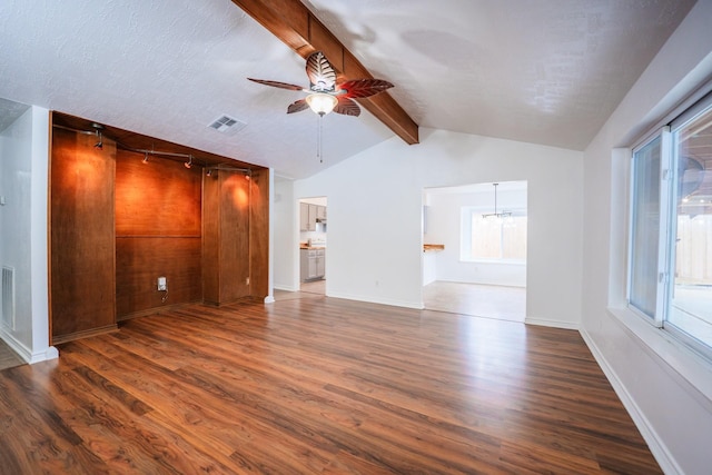 unfurnished living room with a textured ceiling, ceiling fan with notable chandelier, lofted ceiling with beams, and dark hardwood / wood-style floors