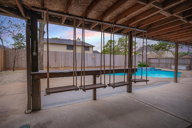 pool at dusk with a patio area