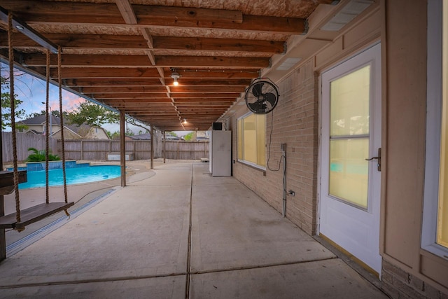 pool at dusk with a patio