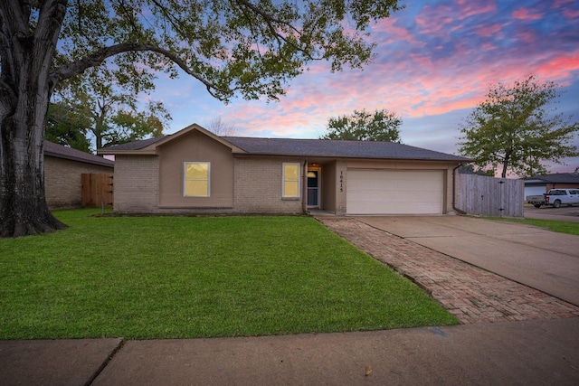 single story home featuring a lawn and a garage