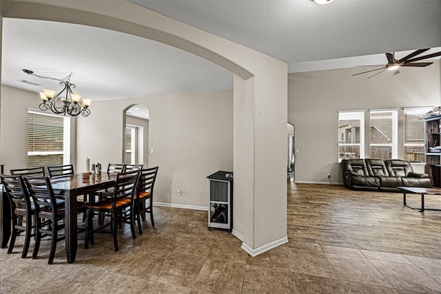 dining space featuring a textured ceiling, ceiling fan with notable chandelier, and plenty of natural light