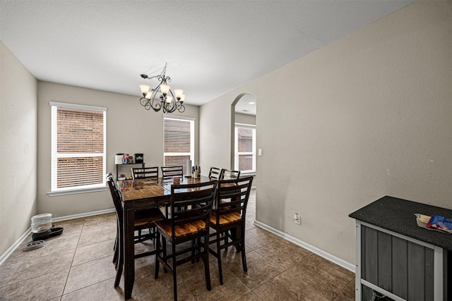 dining area featuring tile patterned floors and a chandelier