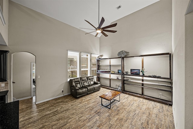 living room with high vaulted ceiling, ceiling fan, and hardwood / wood-style floors