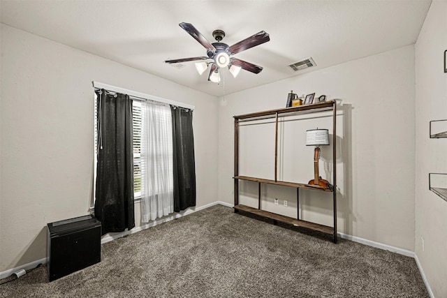 interior space with ceiling fan and dark colored carpet