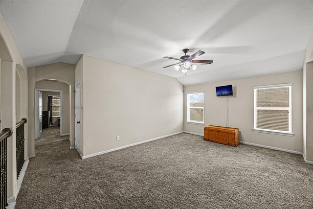 spare room featuring ceiling fan, carpet flooring, and vaulted ceiling