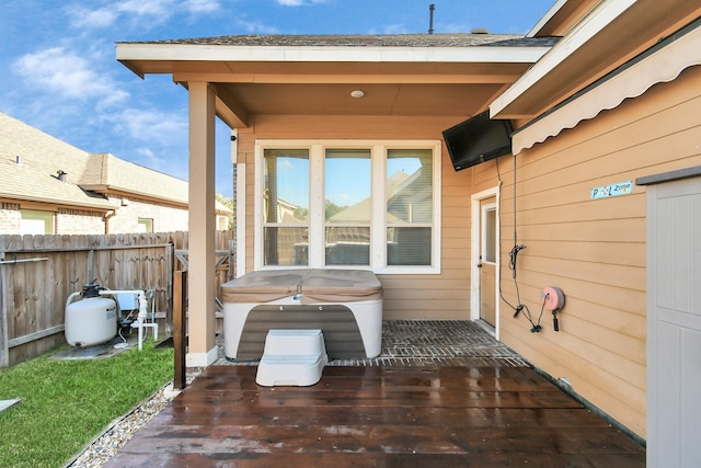 view of patio with a hot tub and a deck