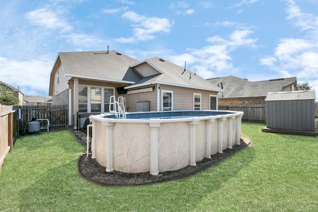 back of property with a fenced in pool and a lawn