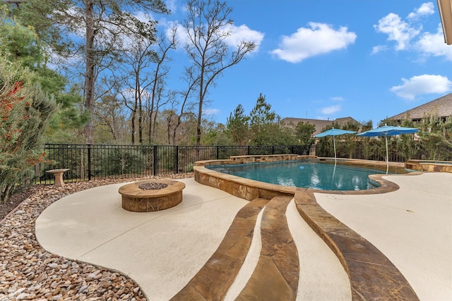 view of pool featuring a patio area, pool water feature, and an outdoor fire pit