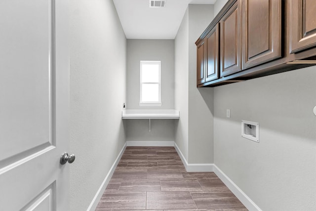 washroom with hookup for a washing machine and cabinets