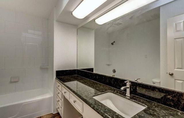 full bathroom featuring toilet, tiled shower / bath, and vanity