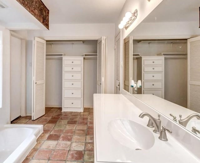 bathroom featuring a washtub and vanity