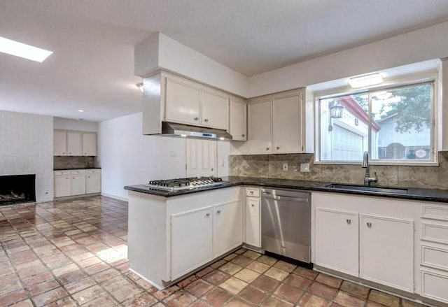 kitchen with stainless steel appliances, white cabinetry, and sink