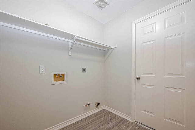 washroom with hardwood / wood-style flooring, hookup for a gas dryer, electric dryer hookup, and hookup for a washing machine