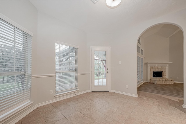 unfurnished living room with light tile patterned floors and a fireplace