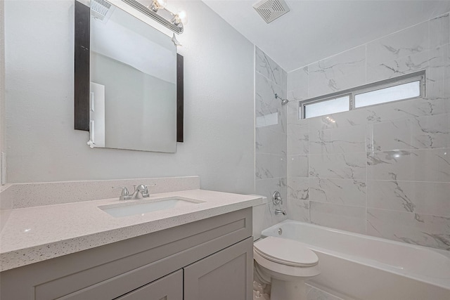 full bathroom with toilet, tiled shower / bath, and vanity