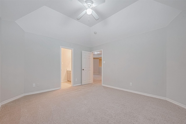 unfurnished bedroom with ceiling fan, light colored carpet, vaulted ceiling, and ensuite bath