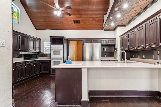 kitchen with kitchen peninsula, appliances with stainless steel finishes, ceiling fan, and dark brown cabinets