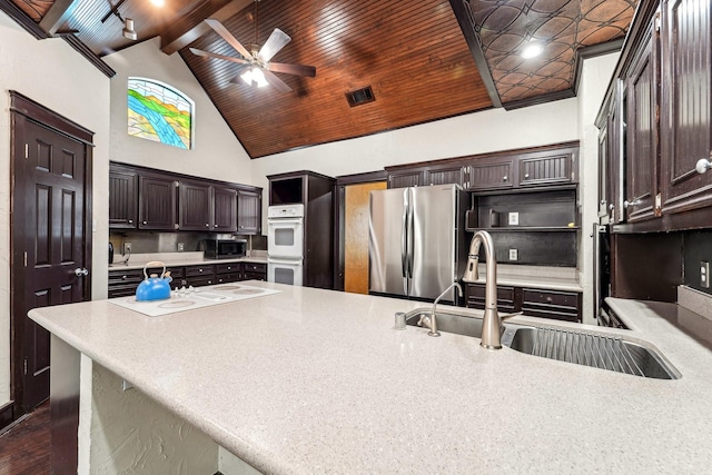 kitchen featuring stainless steel appliances, sink, beamed ceiling, ceiling fan, and wood ceiling