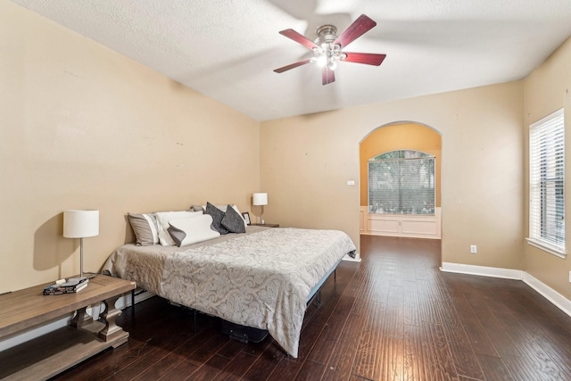 bedroom featuring a textured ceiling, ceiling fan, and dark hardwood / wood-style floors