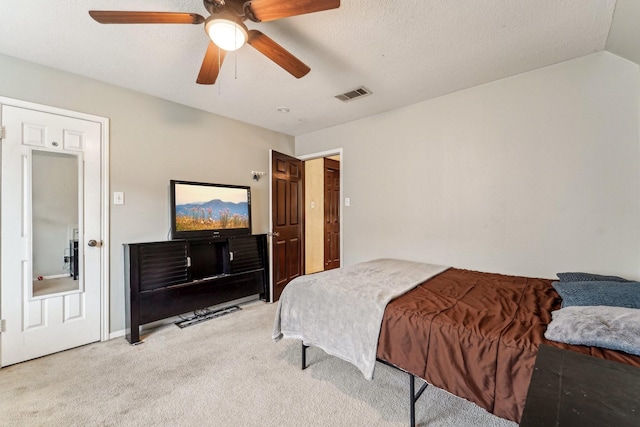 bedroom featuring a textured ceiling, ceiling fan, and light carpet