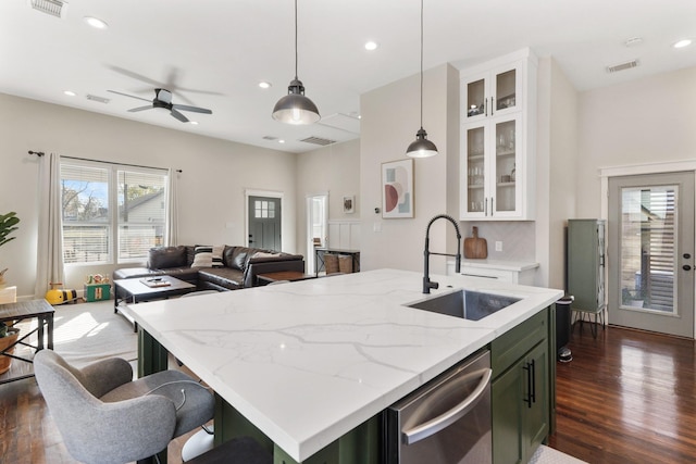 kitchen featuring pendant lighting, dishwasher, an island with sink, sink, and ceiling fan