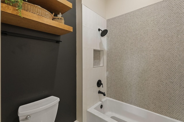 bathroom with toilet and tiled shower / bath