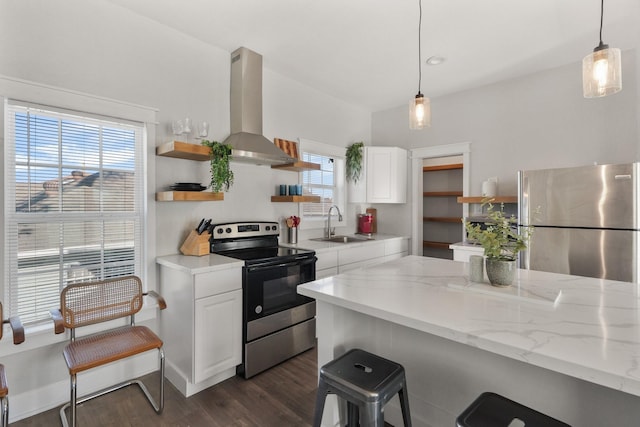 kitchen with white cabinets, exhaust hood, appliances with stainless steel finishes, and light stone counters