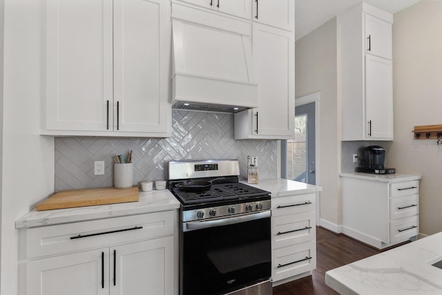 kitchen featuring white cabinetry, custom exhaust hood, decorative backsplash, gas stove, and light stone countertops