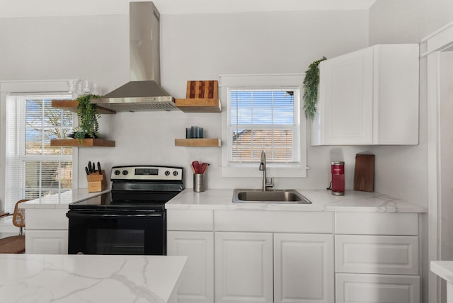 kitchen with white cabinets, wall chimney range hood, black range with electric cooktop, sink, and light stone counters