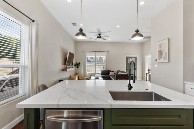 kitchen featuring sink, pendant lighting, light stone counters, and green cabinetry