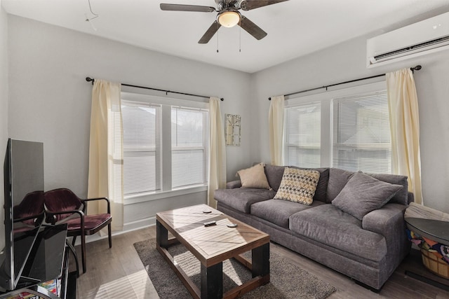 living room featuring ceiling fan, light hardwood / wood-style flooring, and a wall unit AC