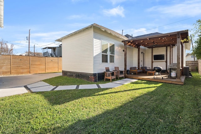 back of property with central AC, a wooden deck, and a lawn