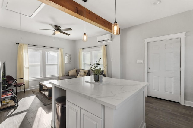 kitchen with white cabinetry, a wall mounted AC, decorative light fixtures, dark wood-type flooring, and light stone counters