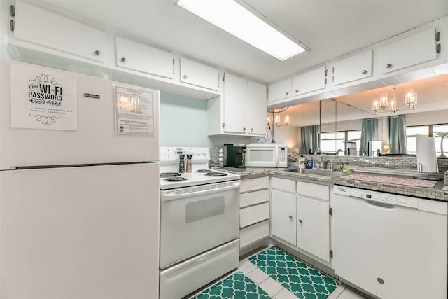 kitchen featuring sink, white appliances, a chandelier, and white cabinets