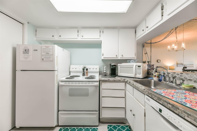 kitchen featuring white appliances, white cabinets, an inviting chandelier, and sink