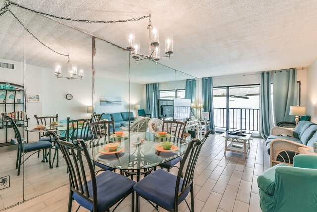 dining area featuring an inviting chandelier and a textured ceiling