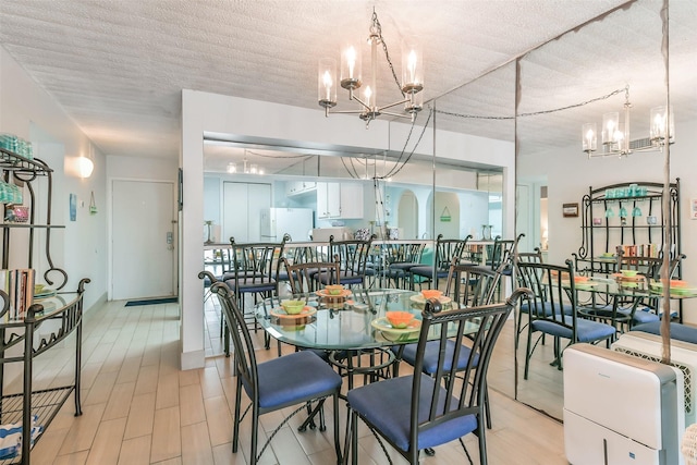 dining space featuring a textured ceiling and an inviting chandelier