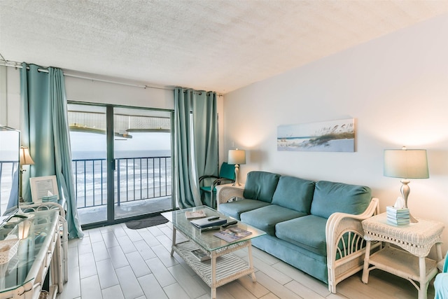 living room with a textured ceiling and a water view