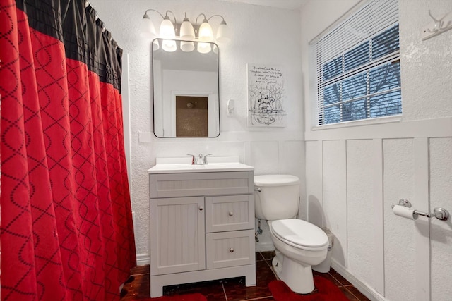 bathroom featuring curtained shower, tile patterned floors, vanity, and toilet