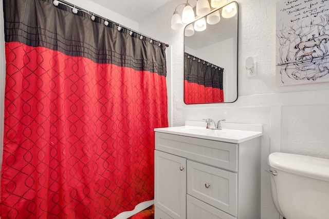 bathroom with toilet, a shower with shower curtain, and vanity